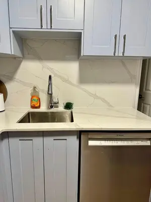 a kitchen with white cabinets and a sink at Private Entire Guest Suite, 1 min to bus stops to Downtown and major attractions in Vancouver