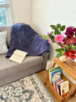 a living room with a couch and a table with books at Private Entire Guest Suite, 1 min to bus stops to Downtown and major attractions in Vancouver