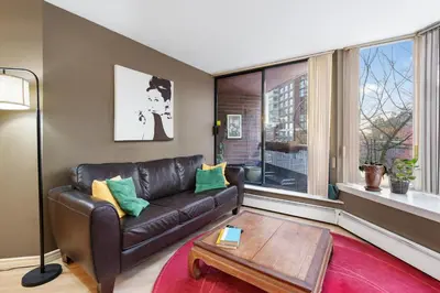 a living room with a leather couch and a table at Cozy Home in Downtown Minutes from Seawall in Vancouver