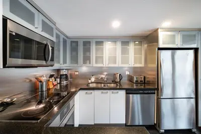 a kitchen with white cabinets and a stainless steel refrigerator at Le Chamois 508 by Outpost Whistler in Whistler