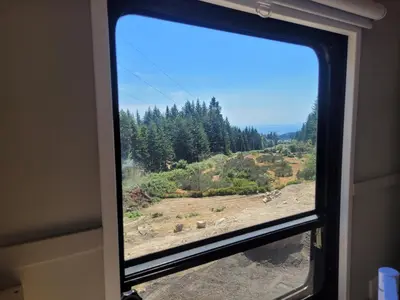 a window in a train looking out at a forest at Gibsons Creek RV Resort and Campground in Gibsons