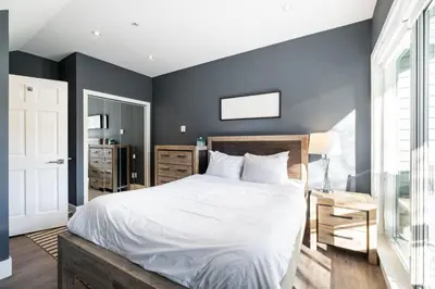 a bedroom with a large white bed and blue walls at Lynx 204 by Outpost Whistler in Whistler