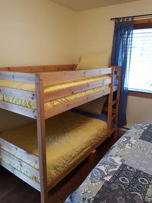 two bunk beds in a room with a window at West facing Waterfront Retreat with private beach, dock access & private buoy in Blind Bay