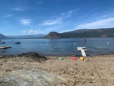 a bench on the shore of a body of water at West facing Waterfront Retreat with private beach, dock access & private buoy in Blind Bay