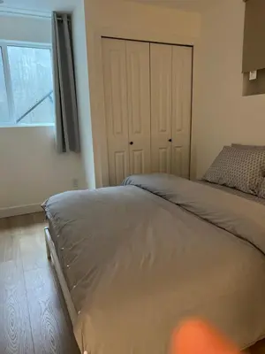 a bedroom with a bed and a large window at 1Bd Modern Suite close to Langley Events Centre and Hwy1 in Langley