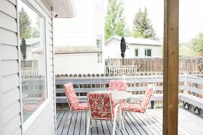 a patio with a table and chairs on a deck at Cozy Calgary Hideaway in Calgary