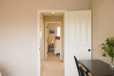 a dining room with a table and a bedroom at Cozy Calgary Hideaway in Calgary