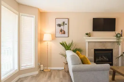 a living room with a chair and a fireplace at Cozy Calgary Hideaway in Calgary