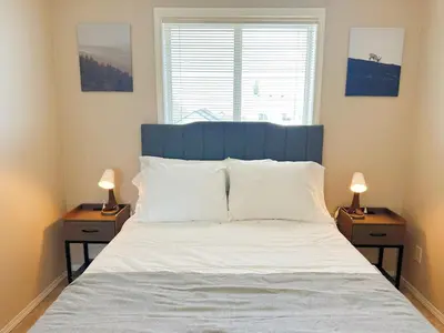 a bedroom with a large bed with two night stands at Cozy Calgary Hideaway in Calgary