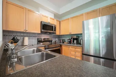 a kitchen with a sink and a stainless steel refrigerator at Northstar 51 by Outpost Whistler in Whistler