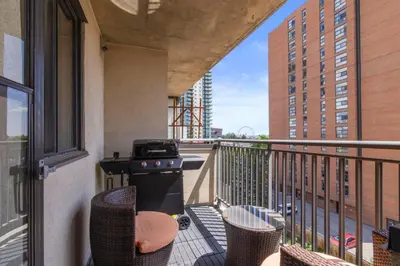a balcony with a stove and chairs on a building at Suite near Downtown, BMO, Stampede, Free Parking in Calgary