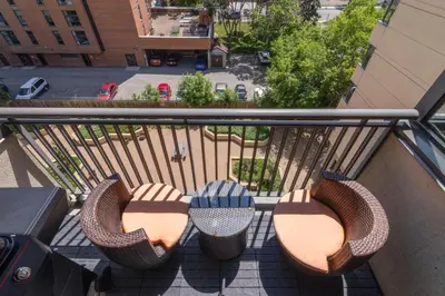 a balcony with chairs and tables on a building at Suite near Downtown, BMO, Stampede, Free Parking in Calgary