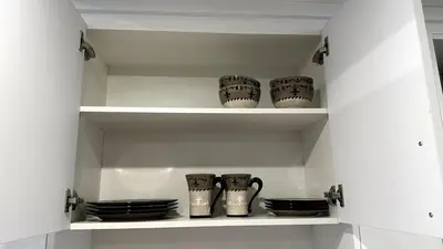 a shelf with cups and plates in a kitchen at 2 Beds, 1 bath Walkout Basement in Calgary