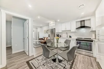 a kitchen and dining room with a glass table and chairs at 2 Beds, 1 bath Walkout Basement in Calgary