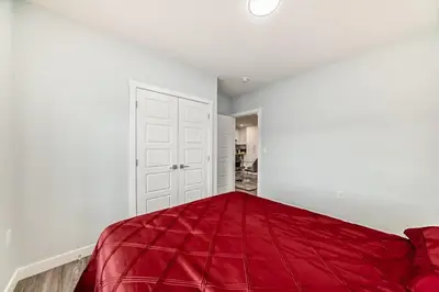 a bedroom with a red blanket on the bed at 2 Beds, 1 bath Walkout Basement in Calgary