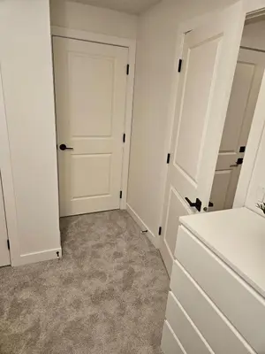 an empty closet with white doors and carpet at Emeka & Comfort in Calgary