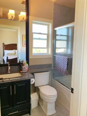 a bathroom with a toilet and a sink and a tub at Vancouver Airport Love Home Inn in Richmond