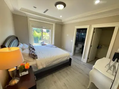 a bedroom with a bed and a window and a desk at Vancouver Airport Love Home Inn in Richmond
