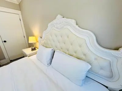 a white bed with a white headboard in a bedroom at Vancouver Airport Love Home Inn in Richmond