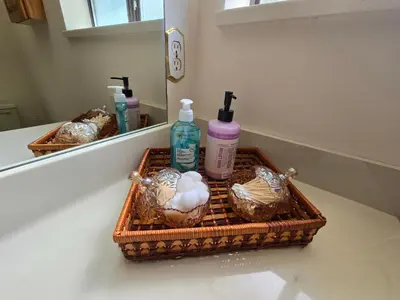 a bathroom counter with a basket with soap and a mirror at Luxury 3BR Home, 2 King Beds, Near cafes and groceries in North Vancouver