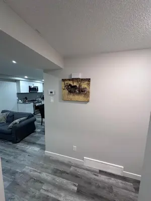 a living room with a couch and a painting on a wall at Elegant Cozy Private Apartment in Calgary