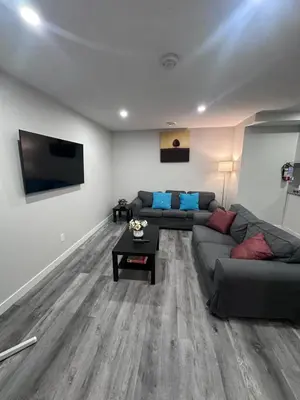 a living room with a couch and a flat screen tv at Elegant Cozy Private Apartment in Calgary