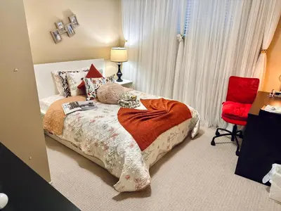 a bedroom with a bed and a red chair at Scorpio House Langley in Langley