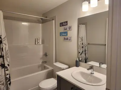 a bathroom with a sink and a toilet and a shower at Cozy & Stylish AC Suite Near YYC Airport in Calgary