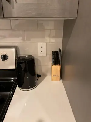 a kitchen counter with a coffee pot and knife block at Cozy & Stylish AC Suite Near YYC Airport in Calgary