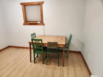a wooden table with four green chairs in a room at Alpenrose 100 King bed Hottub Mountains Views in Golden
