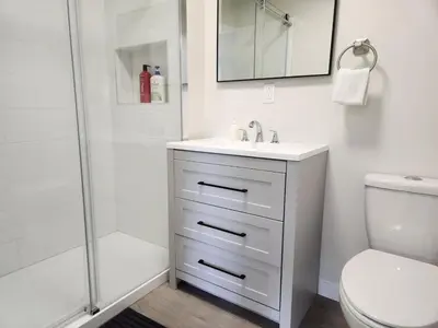a white bathroom with a sink and a shower at Alpenrose 100 King bed Hottub Mountains Views in Golden