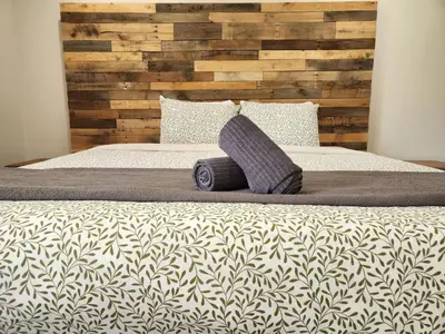a bedroom with a bed with a wooden headboard at Alpenrose 100 King bed Hottub Mountains Views in Golden