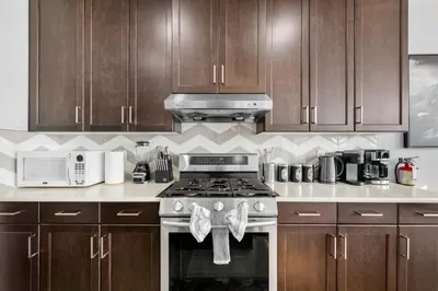 a kitchen with wooden cabinets and a stove top oven at The Ultimate Getaway with Central AC, 3 King Beds, Hot Tub, Pool Table and More in Balzac