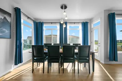 a dining room with blue curtains and a table and chairs at The Ultimate Getaway with Central AC, 3 King Beds, Hot Tub, Pool Table and More in Balzac