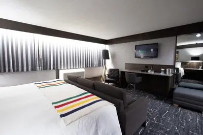 a hotel room with a bed and a living room at Grande Cache Hotel in Grande Cache