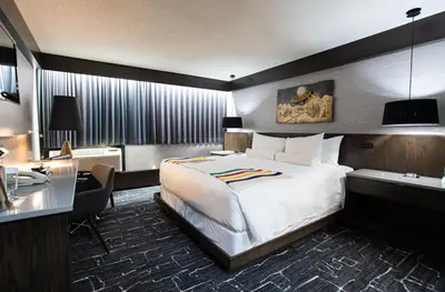 a hotel room with a large bed and a desk at Grande Cache Hotel in Grande Cache