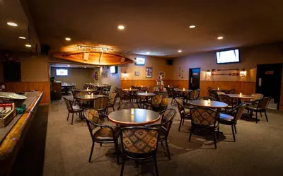 a dining room with tables and chairs in a restaurant at Grande Cache Hotel in Grande Cache