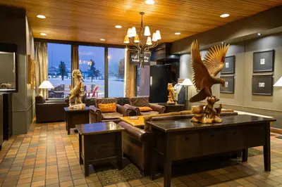 a living room with a couch and eagle statues in it at Grande Cache Hotel in Grande Cache