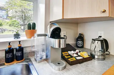 a kitchen with a sink and a counter top with bottles at Viewtiful Stay in Ladysmith