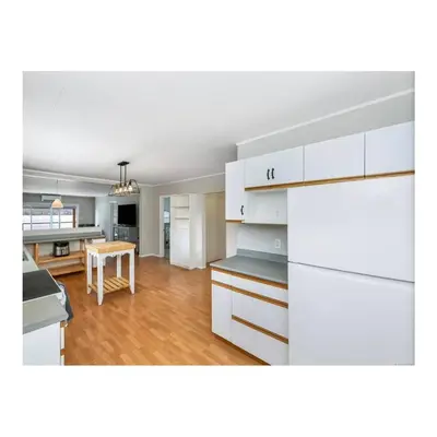 a kitchen with white cabinets and a table at Youbou Lakefront Getaway Relax And Unwind in Youbou