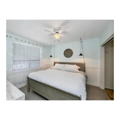 a bedroom with a white bed and a ceiling fan at Youbou Lakefront Getaway Relax And Unwind in Youbou