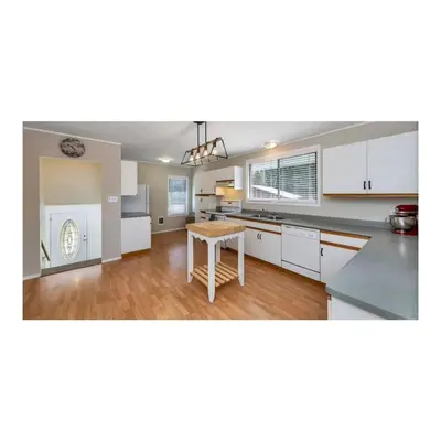 a kitchen with white cabinets and a table at Youbou Lakefront Getaway Relax And Unwind in Youbou