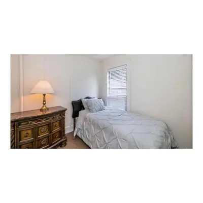 a bedroom with a bed and a table with a lamp at Youbou Lakefront Getaway Relax And Unwind in Youbou