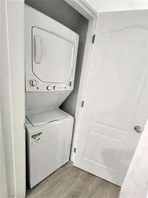 a small white refrigerator in a room with a door at Gorgeous Two Bedroom Suite in a Quiet, Picturesque Neighborhood! in West Vancouver