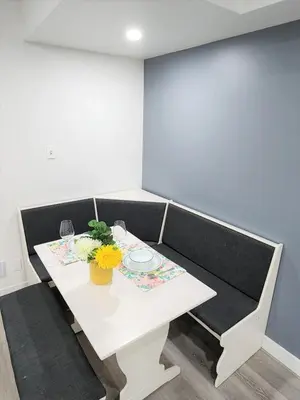 a white table with a vase of flowers on it at Gorgeous Two Bedroom Suite in a Quiet, Picturesque Neighborhood! in West Vancouver