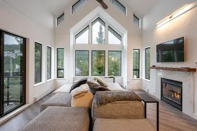 a living room with two couches and a fireplace at Ravencrest 204 by Outpost Whistler in Whistler