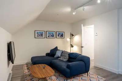 a living room with a blue couch and a wooden table at Ravencrest 204 by Outpost Whistler in Whistler