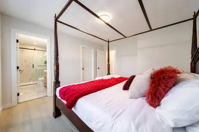 a bedroom with a large bed with a red blanket at #RusticModern3CornerSuite|KingBED|Parking|WEM|wifi in Edmonton