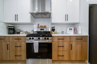 a kitchen with white cabinets and a black stove at #RusticModern3CornerSuite|KingBED|Parking|WEM|wifi in Edmonton