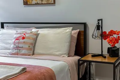 a bed with white pillows and a table with a lamp at ~CozySpacious3bedroomRetreat~FREEparking•2.5bath in Edmonton